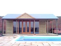 Pavilion used for swimming pool changing room with full length glass doors and windows. Additional gable to front of roof