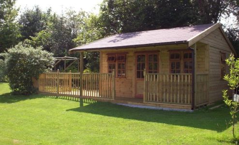 The Warwick Buildings Garden Pavilion with an extended decked area. A popular choice for a variety of uses such as a Barbecue or Pool Room, Playroom or  storage for garden furniture during the winter months